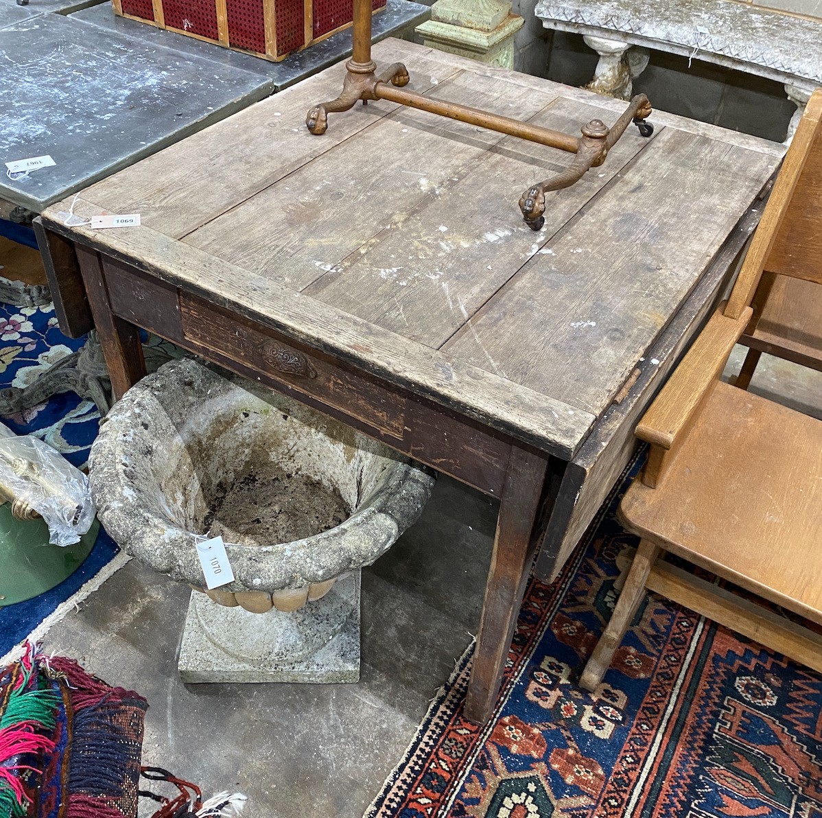 An Edwardian oak work table with drop flaps and frieze drawer, width 93cm